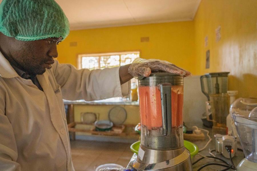 Mtisunge processes nutritious fresh juice for pregnant women in his community. Photo: WFP/Francis Thawani